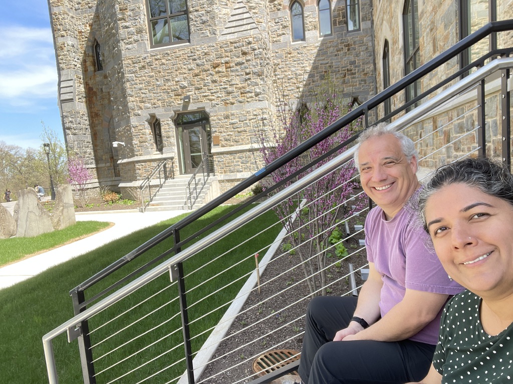 Nandini Deo and Ziad Munson sitting on steps outside a stone campus building
