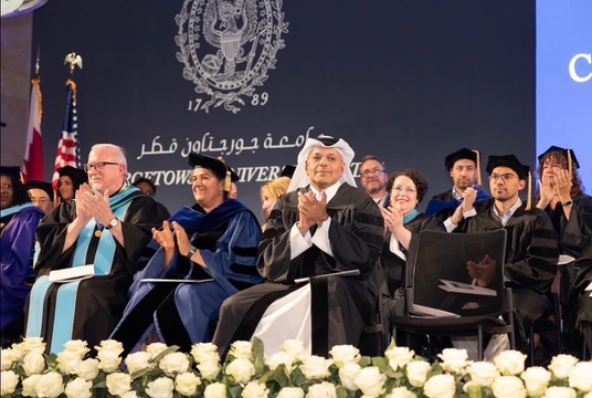 Faculty and dignitaries applauding on stage at the Georgetown University in Qatar convocation